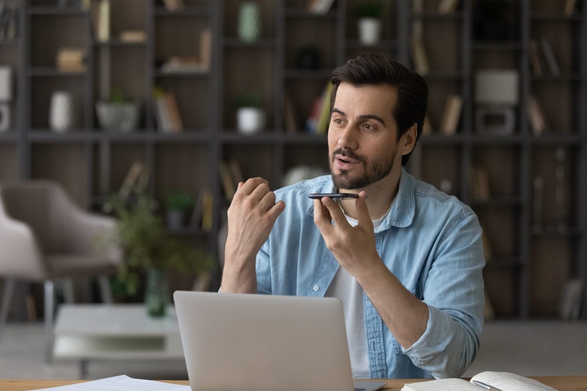 Confident male remote worker use smartphone with voice recognition app adapting as ai changes the game