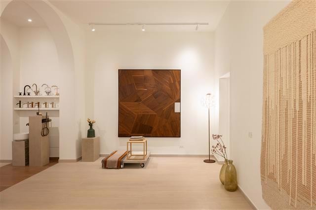 Minimalist room with light walls and floor featuring a large wooden art piece modern chair tall vase with branches and a wall tapestry The abitzai project brings rome inspired design details to the small sink area with shelves and decor Warm ambient lighting throughout Minimalist room with light walls and floor featuring a large wooden art piece modern chair tall vase with branches and a wall tapestry The abitzai project brings rome inspired design details to the small sink area with shelves and decor Warm ambient lighting throughout Abitzai project | in the heart of rome a space where matter becomes design