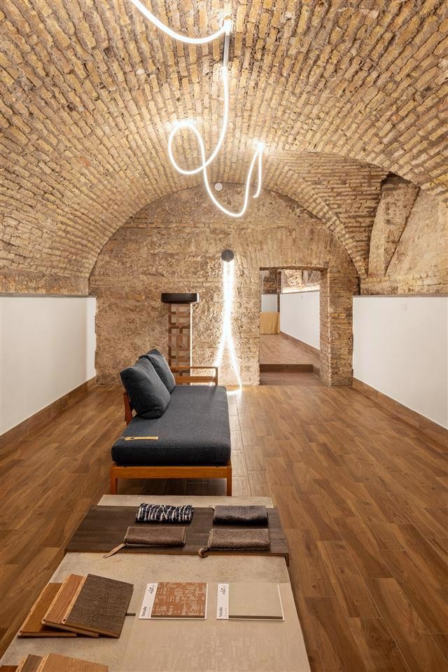 A room in rome with arched brick ceilings wooden flooring and a modern wooden bench with dark cushions embodies refined design A sculptural light fixture hangs above a table displaying fabric samples from the abitzai project A room in rome with arched brick ceilings wooden flooring and a modern wooden bench with dark cushions embodies refined design A sculptural light fixture hangs above a table displaying fabric samples from the abitzai project Abitzai project | in the heart of rome a space where matter becomes design